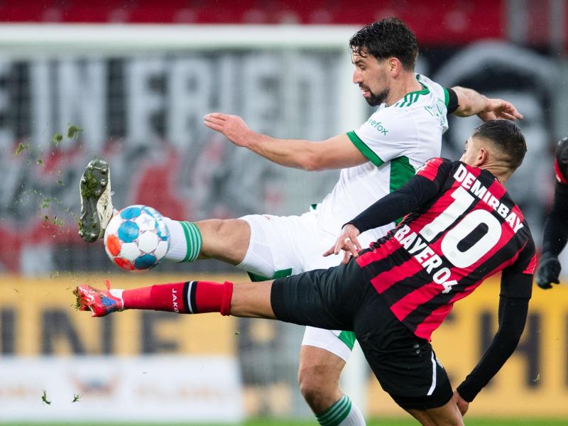 Berlins Rani Khedira (l) und Leverkusens Kerem Demirbay kämpfen um den Ball. Foto: Marius Becker/dpa