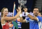 Kristina Mladenovic und Ivan Dodig halten ihre Trophäe nach ihrem Sieg in die Höhe. Foto: Andy Brownbill/AP/dpa
