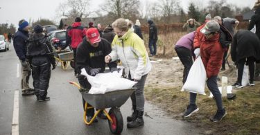 Im dänischen Odense füllen Bewohner Sandsäcke auf, um sich vor Sturm «Malik» zu schützen. Foto: Tim Kildeborg Jensen/Ritzau Scanpix/AP/dpa