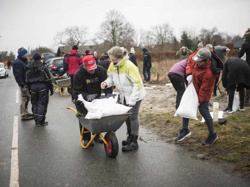Im dänischen Odense füllen Bewohner Sandsäcke auf, um sich vor Sturm «Malik» zu schützen. Foto: Tim Kildeborg Jensen/Ritzau Scanpix/AP/dpa