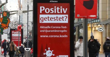 Eine Corona-Hinweistafel in der Kölner Innenstadt. Foto: Oliver Berg/dpa