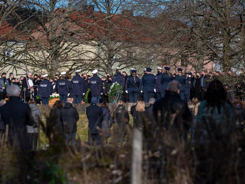 Trauergäste, darunter viele Polizisten, stehen am Grab bei der Beisetzung des Polizisten in Freisen. Foto: Harald Tittel/dpa