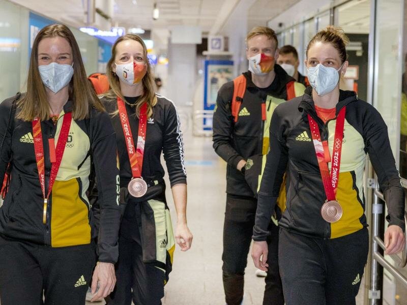 Denise Herrmann, Franziska Preuß, Roman Rees und Vanessa Hinz (l-r) kommen nach den Winterspielen am Frankfurter Flughafen an. Foto: Helmut Fricke/dpa