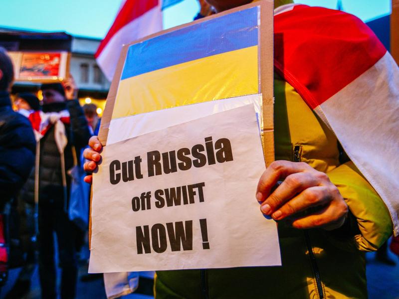 Ein Demonstrant hält ein Schild mit der ukrainischen Flagge und der Aufschrift «Russland jetzt abschneiden!». Foto: Filip Radwanski/SOPA Images via ZUMA Press Wire/dpa