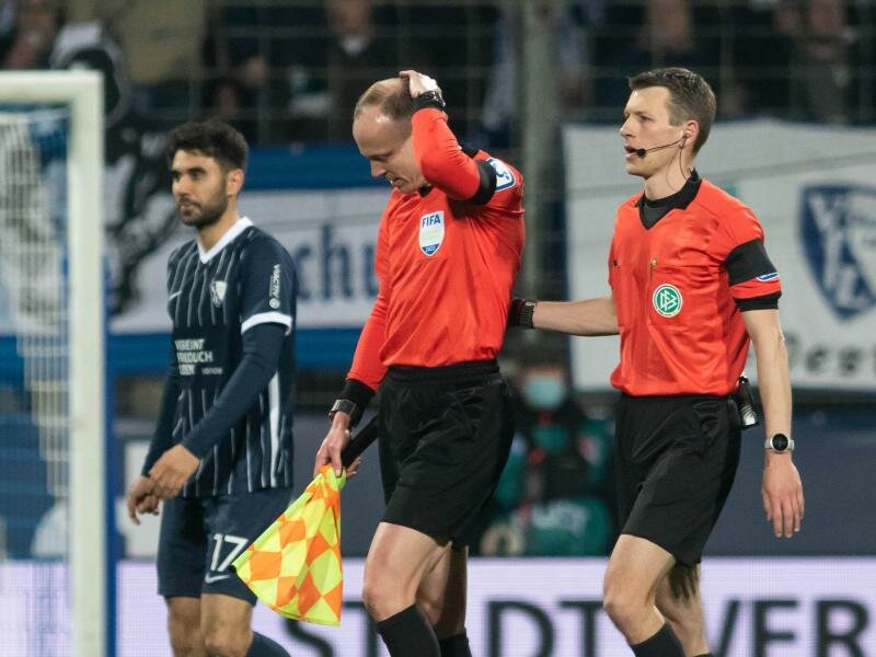 Schiedsrichterassistent Christian Gittelmann (2.v.r.) hat einen Becher an den Kopf bekommen. Foto: Bernd Thissen/dpa