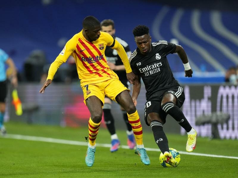 Ousmane Dembélé (l) vom FC Barcelona im Duell mit Real-Profi Vinicius Junior. Foto: Manu Fernandez/AP/dpa