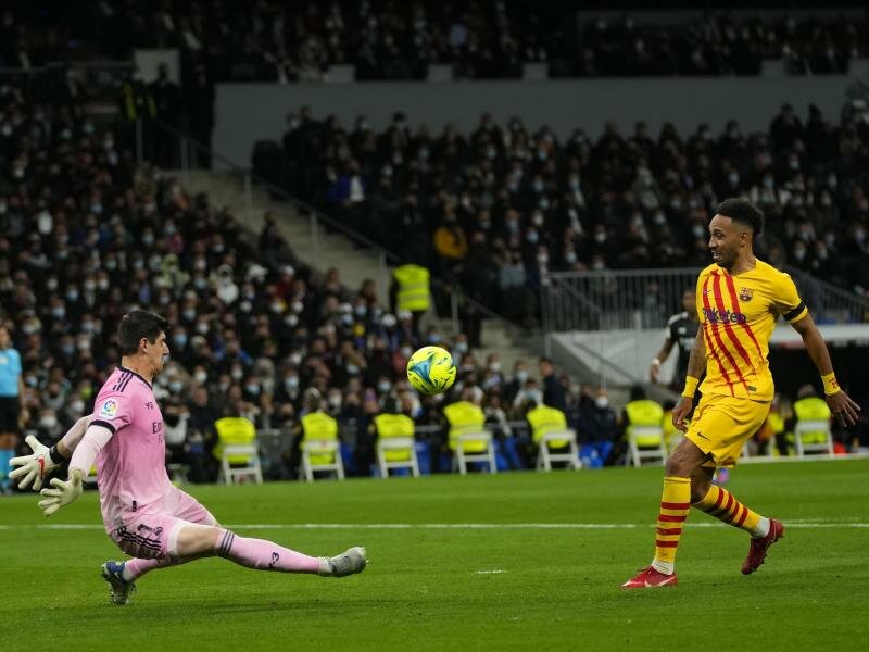 Barcelonas Pierre-Emerick Aubameyang (r) erzielt das Tor zum 4:0 gegen Madrid vorbei an Real-Torhüter Thibaut Courtois. Foto: Manu Fernandez/AP/dpa