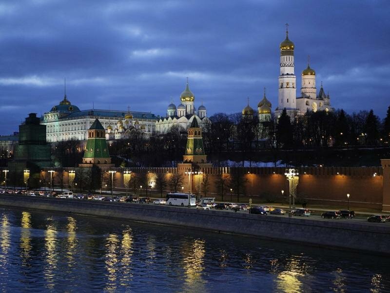 Autos fahren am Ufer der Moskwa vor dem Kreml vorbei. Foto: -/AP/dpa