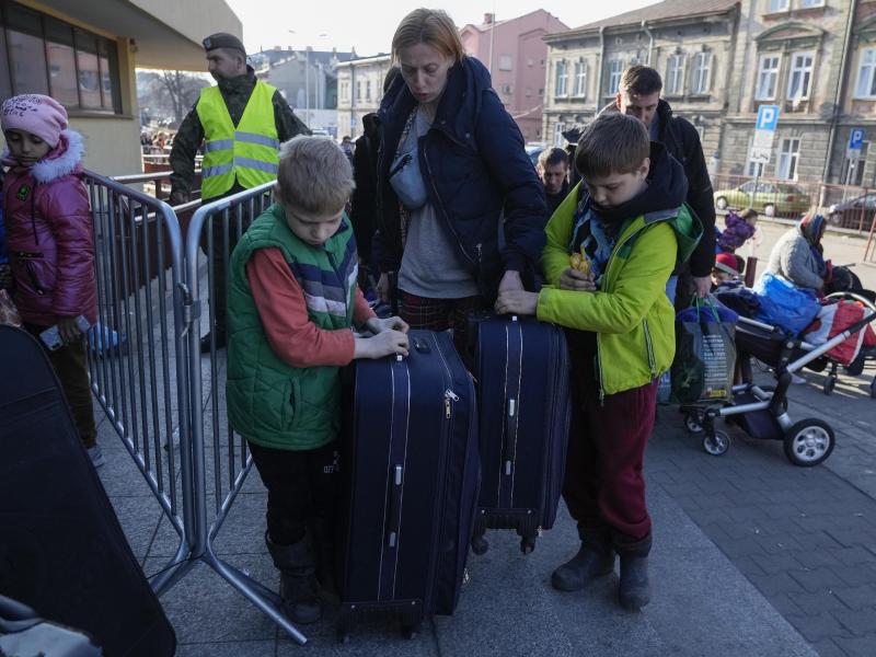 Ukrainische Flüchtlinge und ihre Kinder warten am Bahnhof im polnischen Przemysl. Foto: Sergei Grits/AP/dpa