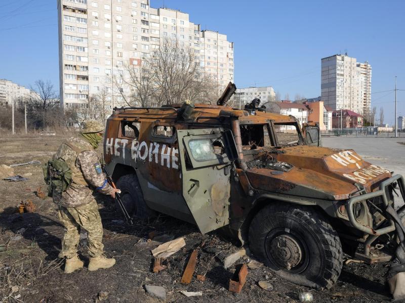 Ein ukrainischer Soldat inspiziert einen zerstörten russischen Schützenpanzer in Charkiw. Foto: Efrem Lukatsky/AP/dpa