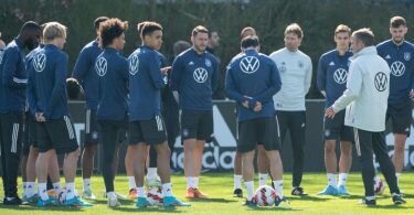 Bundestrainer Hansi Flick (r) wendet sich beim Abschlusstraining an die Spieler der Nationalmannschaft. Foto: Sebastian Gollnow/dpa