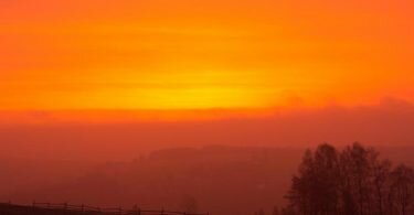 Wegen des Saharastaubs ist der Himmel bei Sonnenaufgang rötlich gefärbt. Foto: Oliver Kaufmann/promovie/dpa
