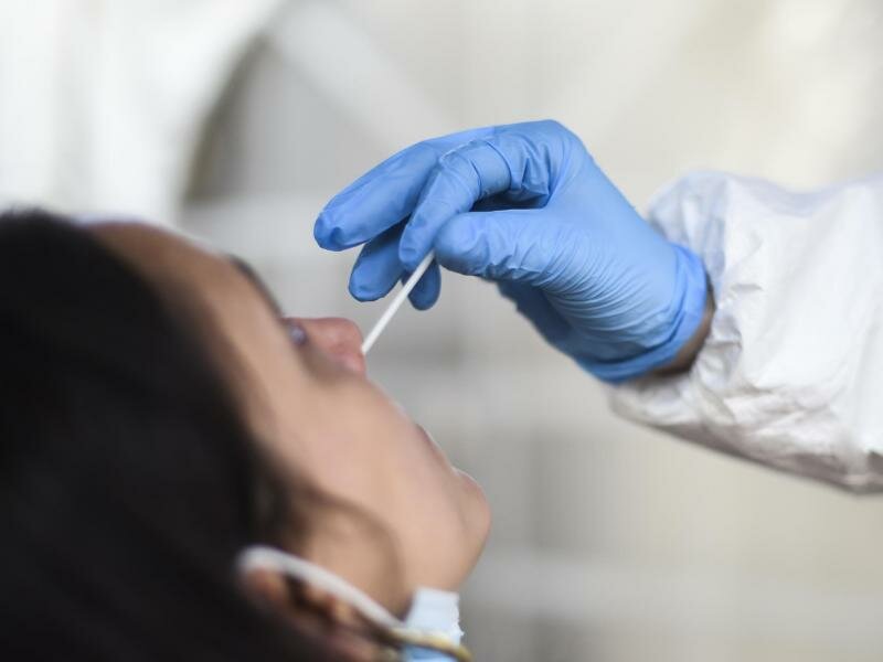 Eine Mitarbeiterin eines Testzentrums nimmt einen Nasenabstrich für einen CoronaTest. Foto: Kira Hofmann/dpa