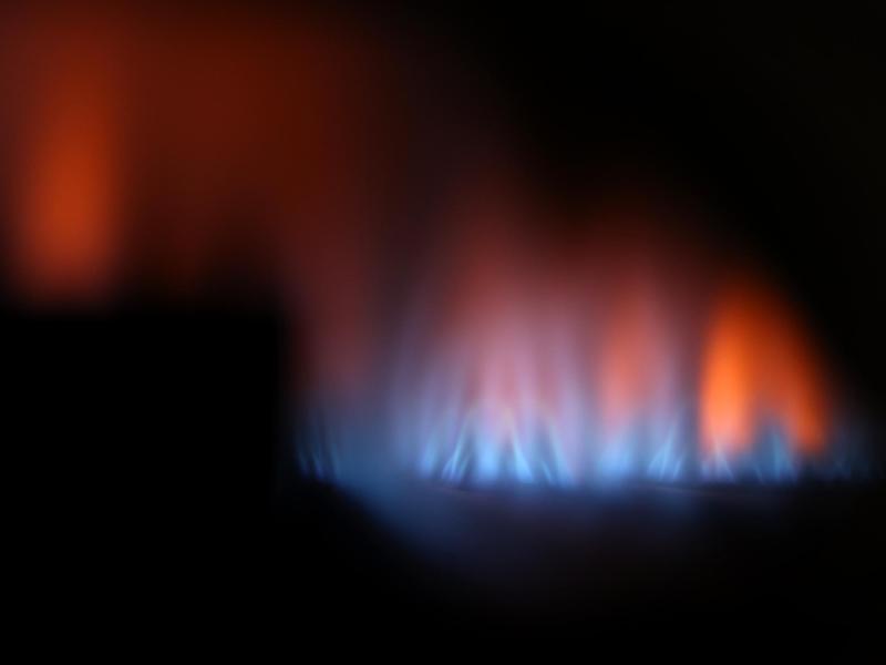Eine Gasflamme brennt hinter dem Sichtfenster eines Gas-Durchlauferhitzers. Foto: Karl-Josef Hildenbrand/dpa