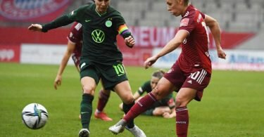 Linda Dallmann (r) spielt den Ball im Hinspiel vor der Wolfsburgerin Svenja Huth. Foto: Angelika Warmuth/dpa