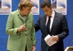 Die damalige Bundeskanzlerin Angela Merkel (l, CDU) spricht mit Nicolas Sarkozy, damals Präsident von Frankreich, am Ende der Eröffnungssitzung des NATO-Gipfels. Foto: Robert Ghement/epa/dpa