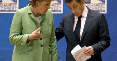 Die damalige Bundeskanzlerin Angela Merkel (l, CDU) spricht mit Nicolas Sarkozy, damals Präsident von Frankreich, am Ende der Eröffnungssitzung des NATO-Gipfels. Foto: Robert Ghement/epa/dpa