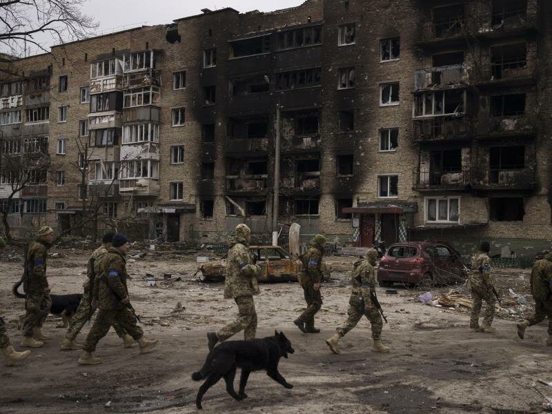 Ukrainische Soldaten begutachten ein schwer beschädigtes Wohnhaus in&nbsp;Irpin. Foto: Felipe Dana/AP/dpa