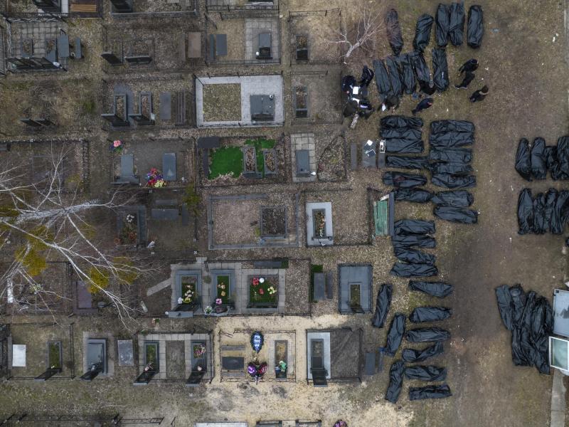 Polizisten arbeiten auf einem Friedhof in Kiew an der Identifizierung von Toten. Foto: Rodrigo Abd/AP/dpa