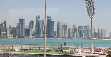 Arbeiter sind auf einer Baustelle an der Promenade Corniche mit Blick auf die Skyline von West Bay Doha zu sehen. Foto: Christian Charisius/dpa