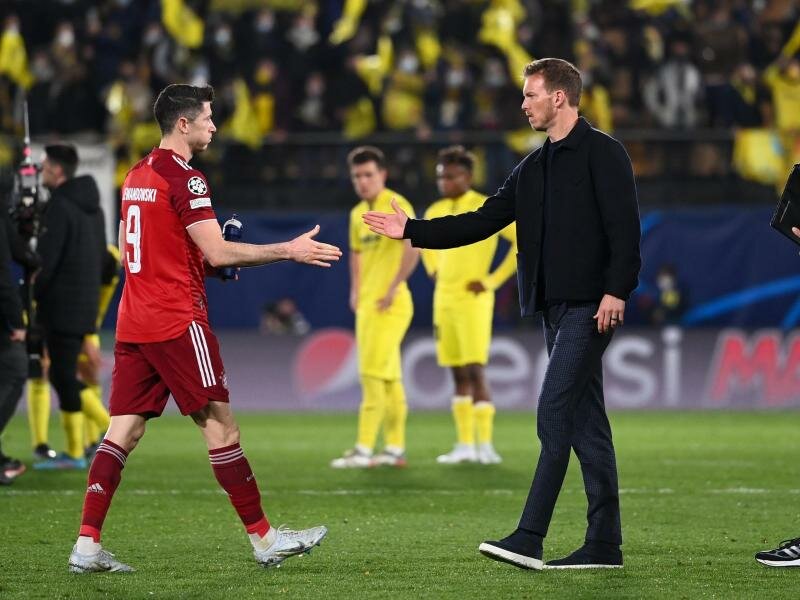 Münchens Trainer Julian Nagelsmann (M) nach dem Spiel in Villarreal beim Handschlag mit Robert Lewandowski. Foto: Sven Hoppe/dpa