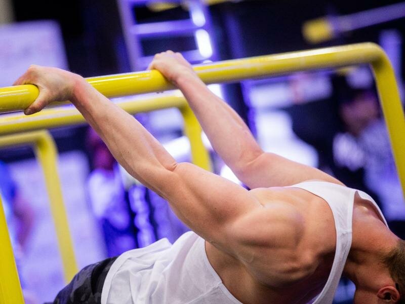 Ein Messebesucher zeigt eine Calisthenics-Übung auf der Fitnessmesse Fibo. Foto: Rolf Vennenbernd/dpa