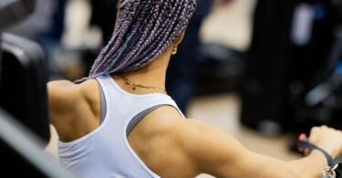 Dior führt an einem Messestand auf der Fitnessmesse Fibo ein Muskeltraining aus. Foto: Rolf Vennenbernd/dpa