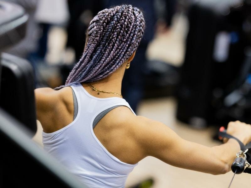Dior führt an einem Messestand auf der Fitnessmesse Fibo ein Muskeltraining aus. Foto: Rolf Vennenbernd/dpa