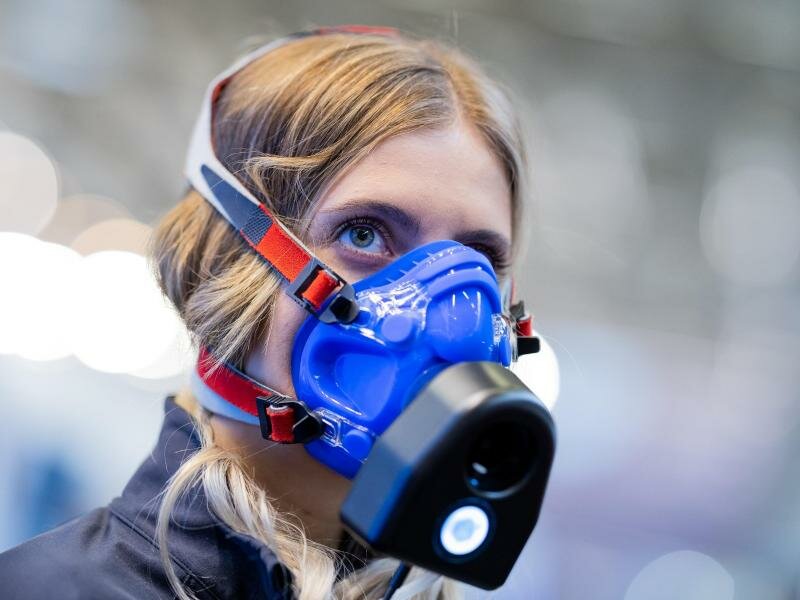 Eine Mitarbeiterin zeigt an einem Messestand auf der Fitnessmesse Fibo ein Messgerät für eine Atemanalyse. Foto: Rolf Vennenbernd/dpa