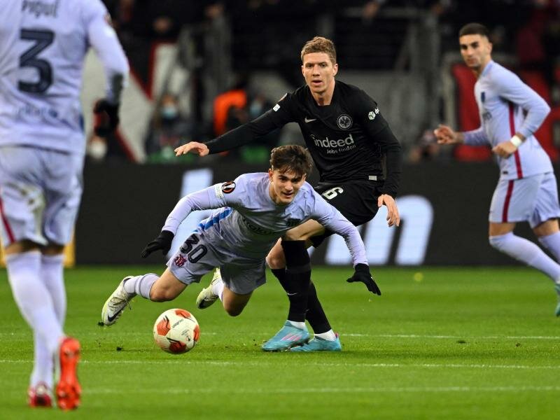 Frankfurts Kristijan Jakic (r) und Gavi vom FC Barcelona kämpfen um den Ball. Foto: Arne Dedert/dpa
