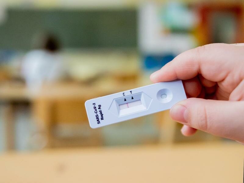 Ein Schüler hält bei einem Probelauf mit Corona-Schnelltests an der Grundschule in der Köllnischen Heide in Berlin-Neukölln seinen negativen Test in die Kamera. Foto: Christoph Soeder/dpa