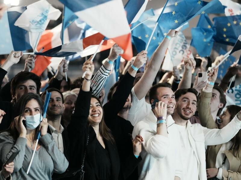 Anhänger von Emmanuel Macron schwenken in Paris französische und europäische Flaggen. Foto: Thibault Camus/AP/dpa