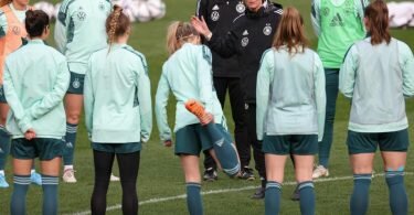 Beim Abschlusstraining hat Bundestrainerin Martina Voss-Tecklenburg (4.v.r.) die Spielerinnen um sich versammelt. Foto: Friso Gentsch/dpa