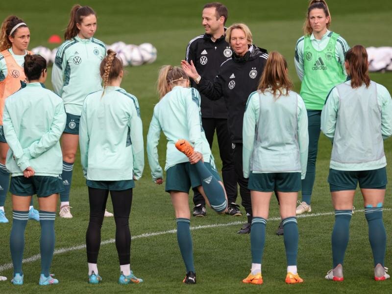 Beim Abschlusstraining hat Bundestrainerin Martina Voss-Tecklenburg (4.v.r.) die Spielerinnen um sich versammelt. Foto: Friso Gentsch/dpa