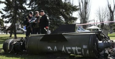 Ukrainische Soldaten während Ermittlungsarbeiten neben einem Fragment einer Tochka-U-Rakete mit der russischen Aufschrift «Für Kinder» nahe des Bahnhofs in Kramatorsk. Foto: Andriy Andriyenko/AP/dpa