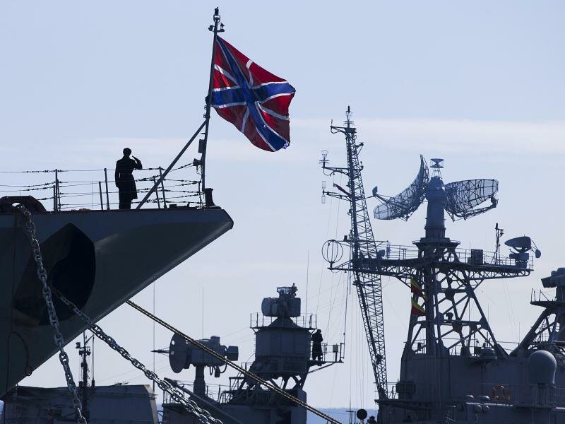 Ein russischer Matrose (l) salutiert am Bug des Raketenkreuzers «Moskwa». Foto: Pavel Golovkin/AP/dpa