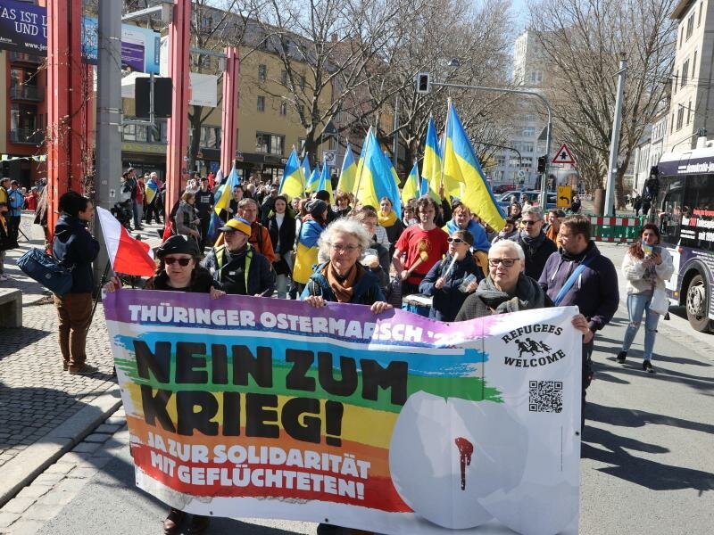 Teilnehmer eines Ostermarsches laufen in Jena nach einer Kundgebung auf dem Holzmarkt durch die Innenstadt. Foto: Bodo Schackow/dpa
