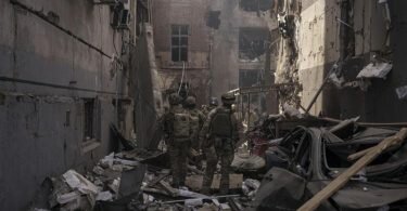 Ukrainische Soldaten gehen zwischen den Trümmern beschädigter Gebäude nach einem russischen Angriff in Charkiw. Foto: Felipe Dana/AP/dpa