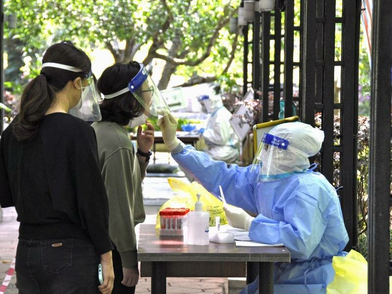 Bewohnerinnen einer Wohnanlage in Shanghai bei einem PCR-Test. Die Corona-Zahlen in der chinesischen Millionenmetropole bleiben trotz Lockdown hoch. Foto: -/kyodo/dpa
