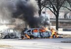 Zwei Autos stehen auf einem Parkplatz in Norrköping während der Ausschreitungen in Flammen. Foto: Stefan Jerrevång/TT NEWS AGENCY/AP/dpa