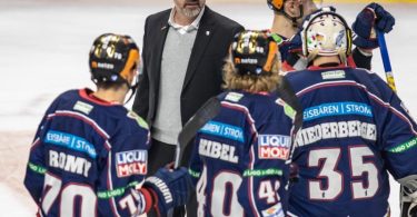 Berlins Cheftrainer Serge Aubin (2.v.l) unterhält sich nach einem Spiel mit seinen Spielern auf dem Eis. Foto: Andreas Gora/dpa