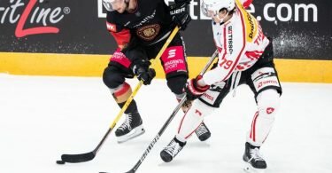 Tobias Eder (l) und der Schweizer Calvin Thürkauf im Zweikampf um den Puck. Foto: Matthias Balk/dpa