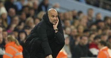 Pep Guardiola, Trainer von Manchester City, hockt an der Seitenlinie und studiert das Spiel seiner Mannschaft. Foto: Dave Thompson/AP/dpa