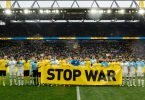 Vor dem Spiel geben beide Teams mit einem Banner ein Statement gegen den Krieg in der Ukraine ab. Foto: Bernd Thissen/dpa