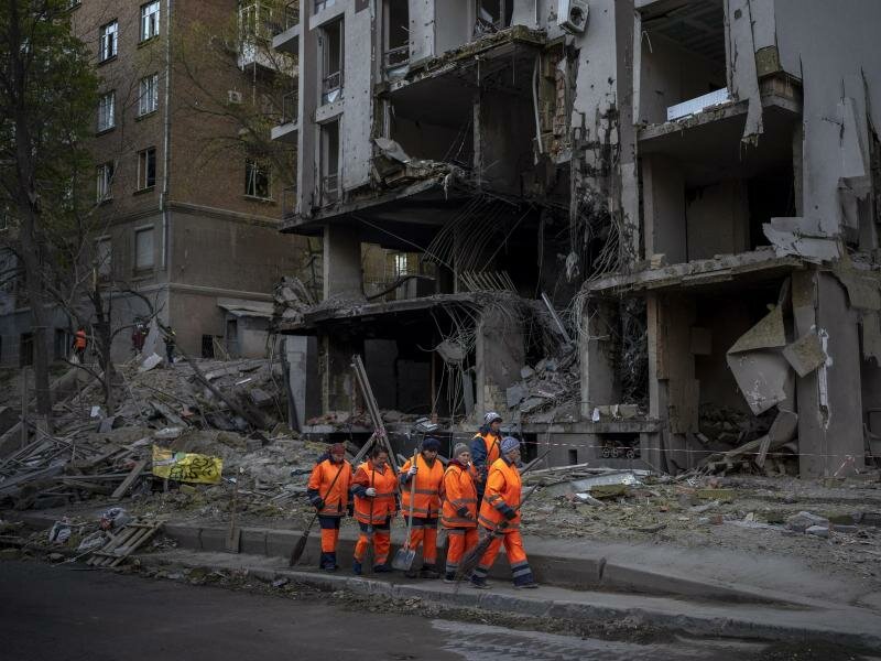 Ein Aufräumtrupp vor einem durch Raketenbeschuss zerstörten Gebäude in Kiew. Die Explosion ereignete sich zu der Zeit des Besuchs von UN-Generalsekretär Guterres. Foto: Emilio Morenatti/AP/dpa