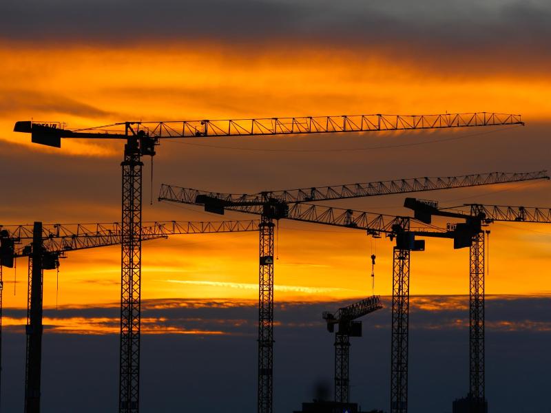 Baukräne am Abendhimmel über Berlin. Das Bruttoinlandsprodukt ist im ersten Quartal um 0,2 Prozent gewachsen. Foto: Gerald Matzka/dpa-Zentralbild/dpa