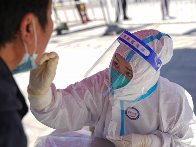 Eine medizinische Angestellte testet einen Anwohner im Bezirk Daxing auf das Coronavirus. Foto: Peng Ziyang/XinHua/dpa