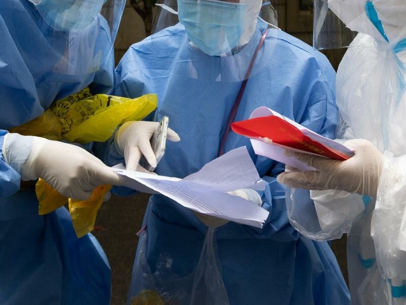 Den falschen abtransportiert:&nbsp;Medizinische Mitarbeiter überprüfen Daten. Foto: Jin Liwang/XinHua/dpa/Symbolbild