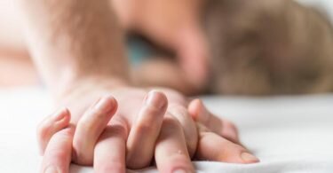 Ein junges Paar liegt im Bett. Laut einer Studie verändert sich unsere Atenzusammensetzung je nach emotionalem Zustand. Foto: Christophe Gateau/dpa