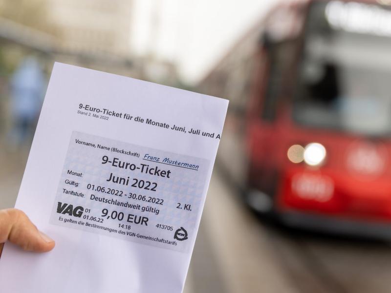 Ein Mitarbeiter der VAG (Verkehrs-Aktiengesellschaft Nürnberg) präsentiert den ausgedruckten Entwurf des 9-Euro-Tickets. Foto: Daniel Karmann/dpa